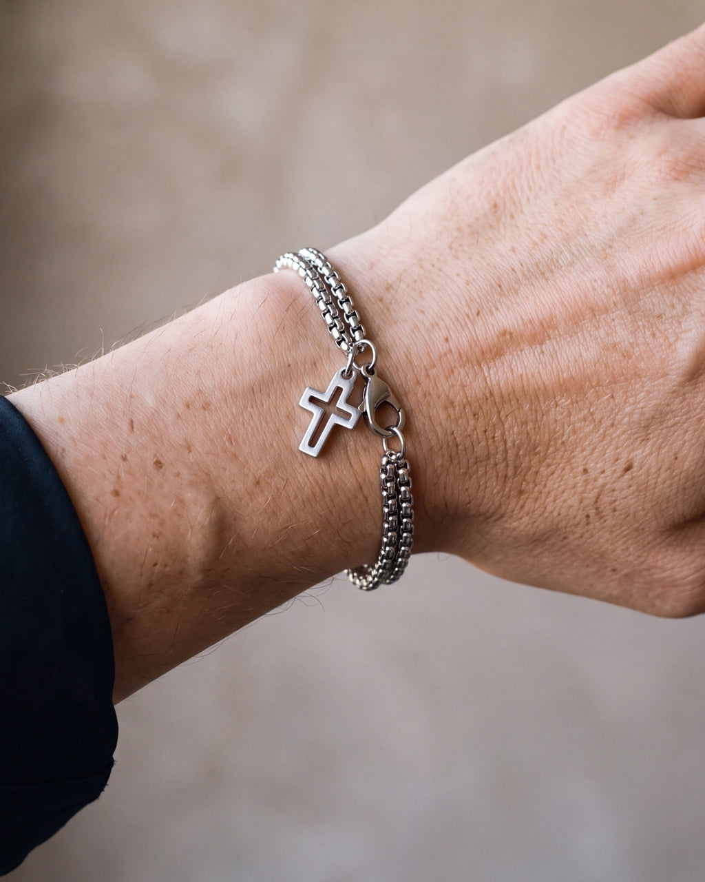 Close-up of the silver Atlas double rolo cross bracelet worn at true size