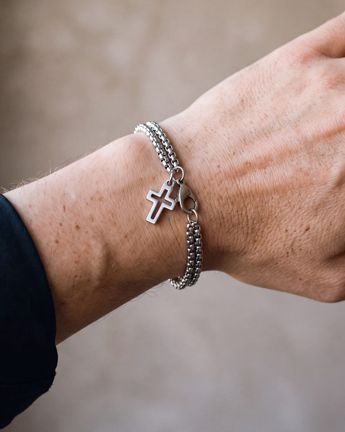 Close-up of the silver Atlas double rolo cross bracelet worn at true size
