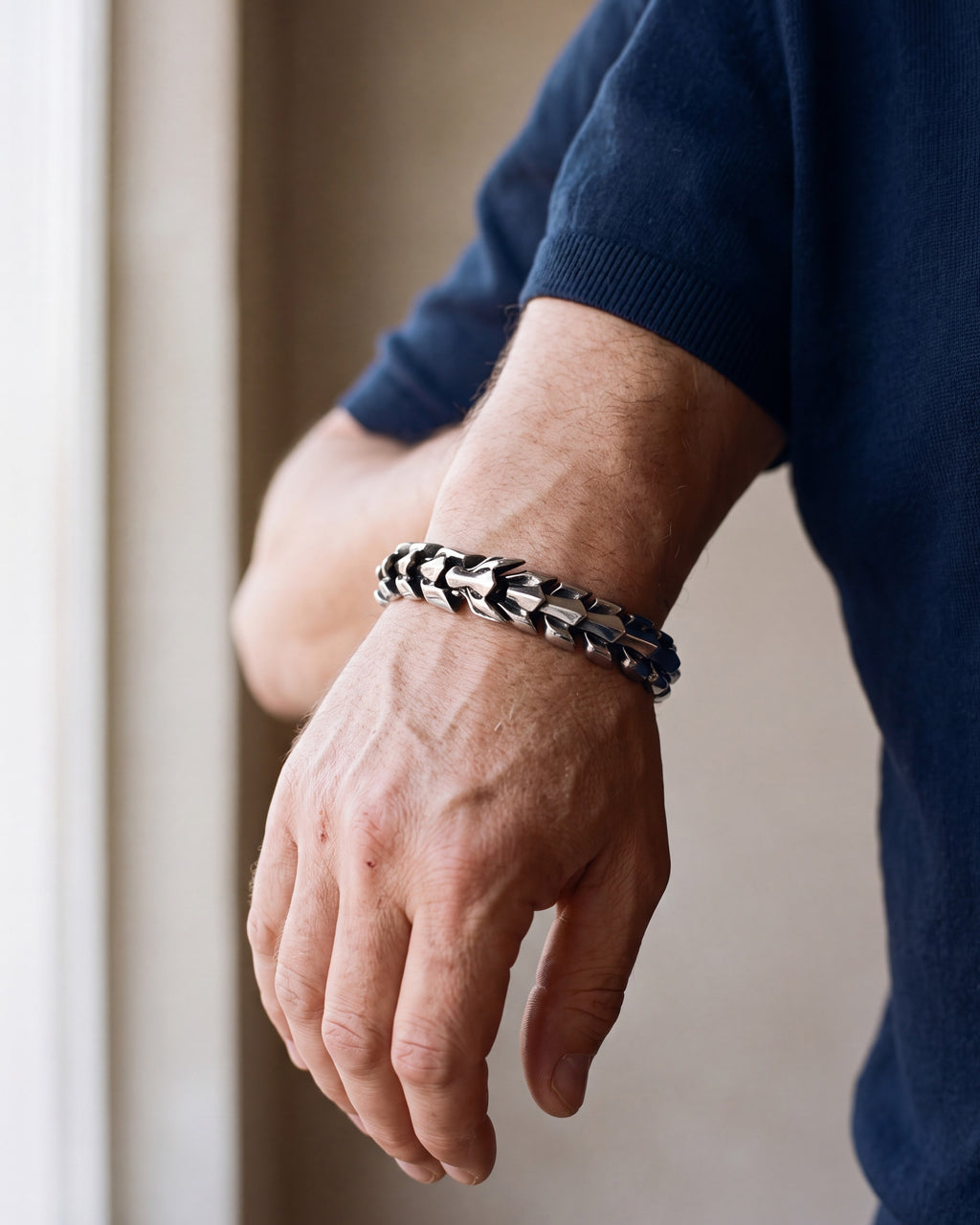 Close-up of the silver Atlas dragon scale bracelet on a man's wrist