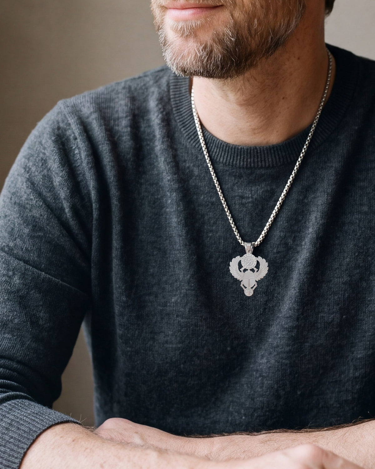 Close-up of the silver-tone Atlas Egyptian scarab Eye of Horus pendant necklace worn, true size
