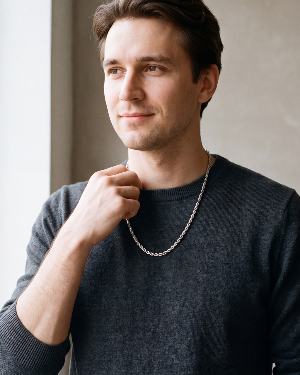 Man in a charcoal sweater with his hand at the collar, wearing the 4 mm silver Atlas rope chain