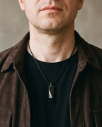 Atlas faceted pendant necklace in black tungsten carbide worn on the chest, close-up