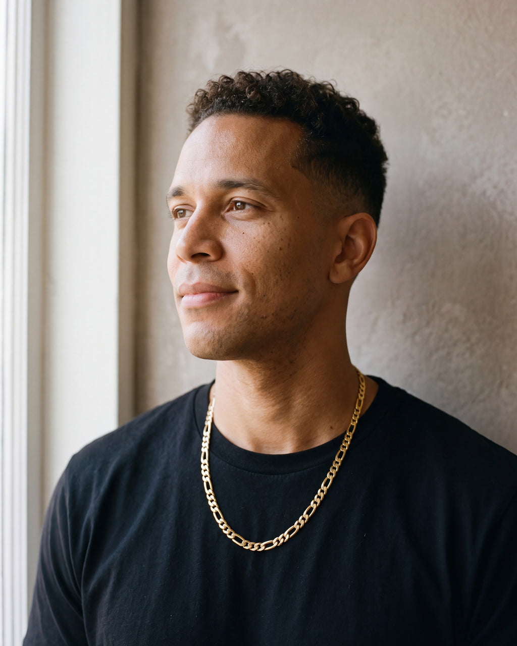 Second man in a plain heavyweight black cotton crew-neck t-shirt (thick wearing the gold-tone Atlas figaro chain