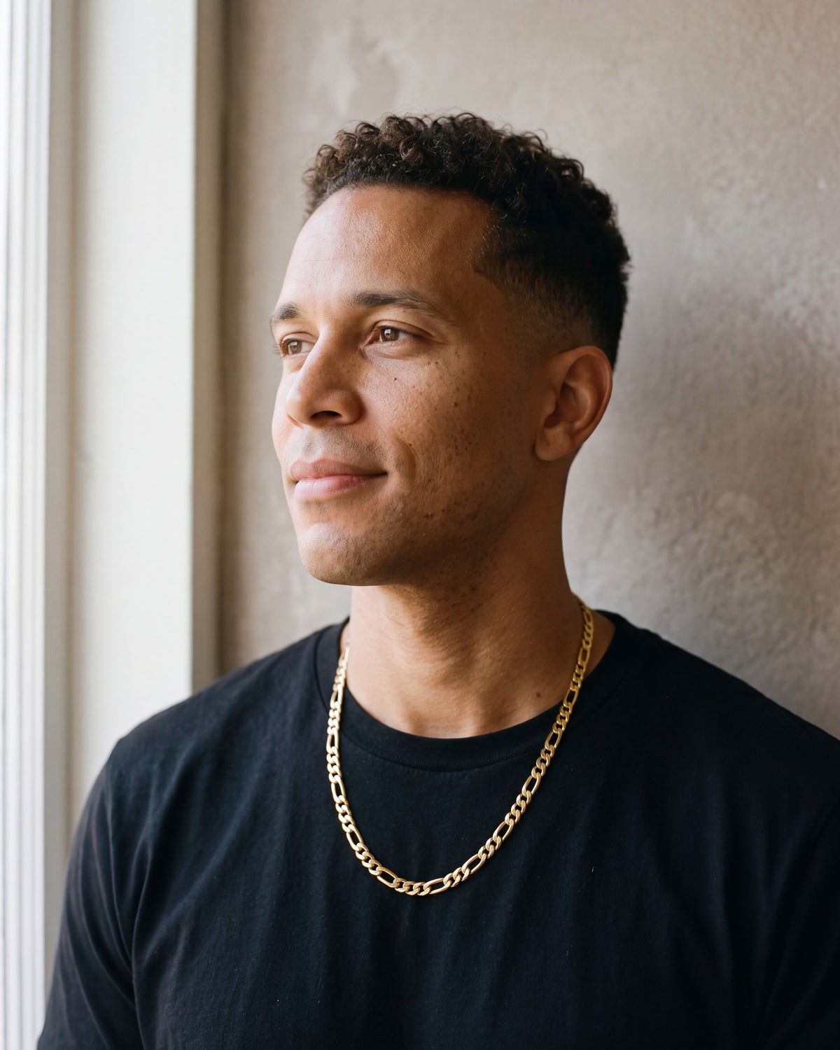 Second man in a plain heavyweight black cotton crew-neck t-shirt (thick wearing the gold-tone Atlas figaro chain