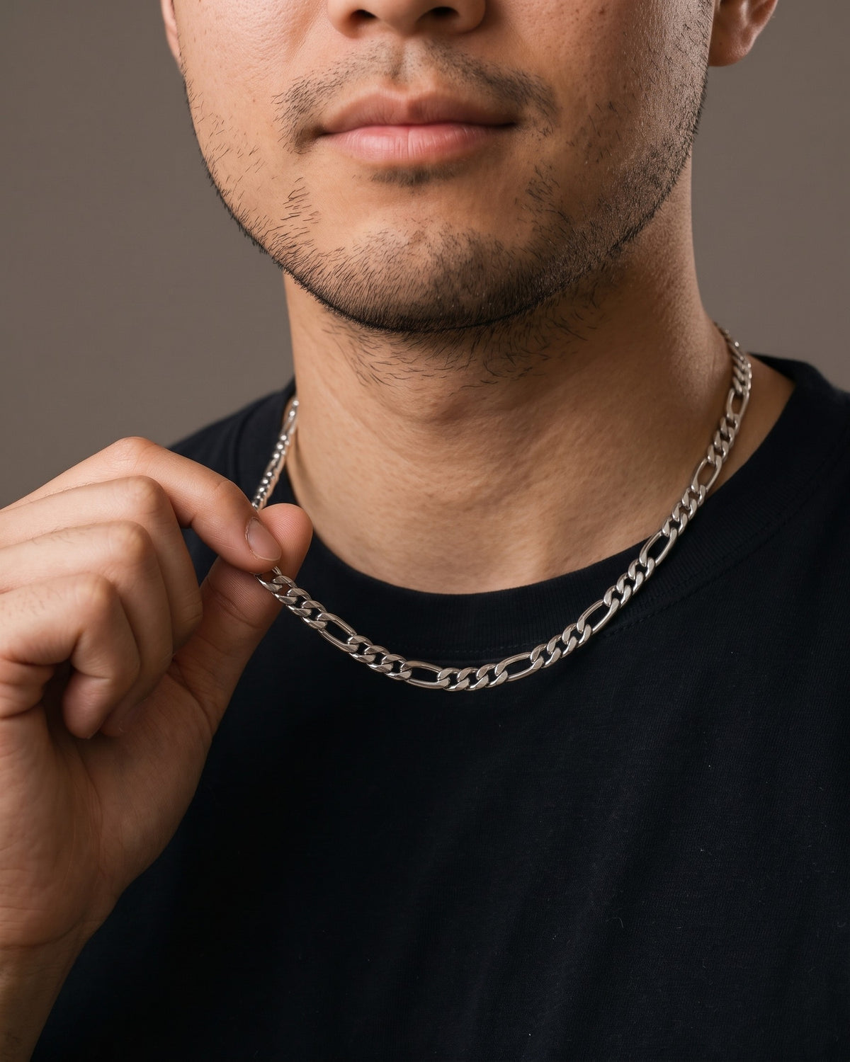 Hand lifting the Atlas Figaro Chain in 304 Stainless Steel at the collarbone