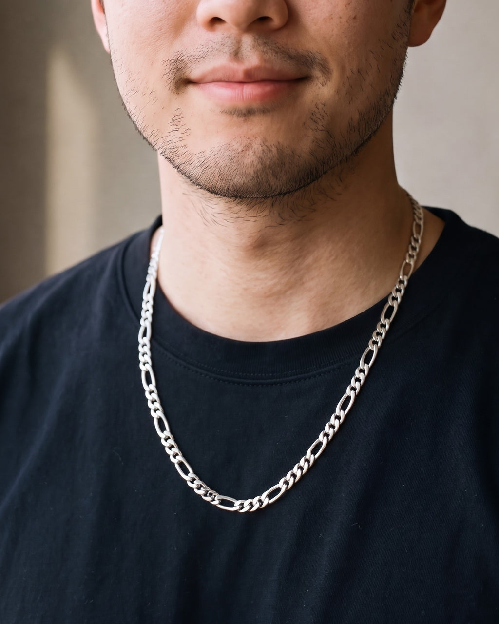Close-up of the silver Atlas Figaro Chain in 304 Stainless Steel worn by a man, shown at true size