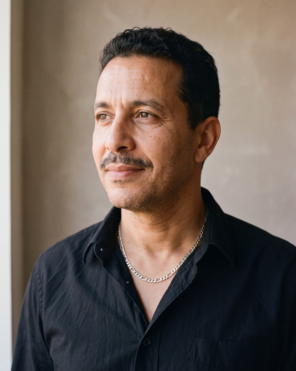 Man in a black shirt by a window wearing the 5 mm silver Atlas Figaro chain