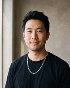 Man in a plain heavyweight black cotton crew-neck t-shirt (thick by a window wearing the silver-tone Atlas figaro chain