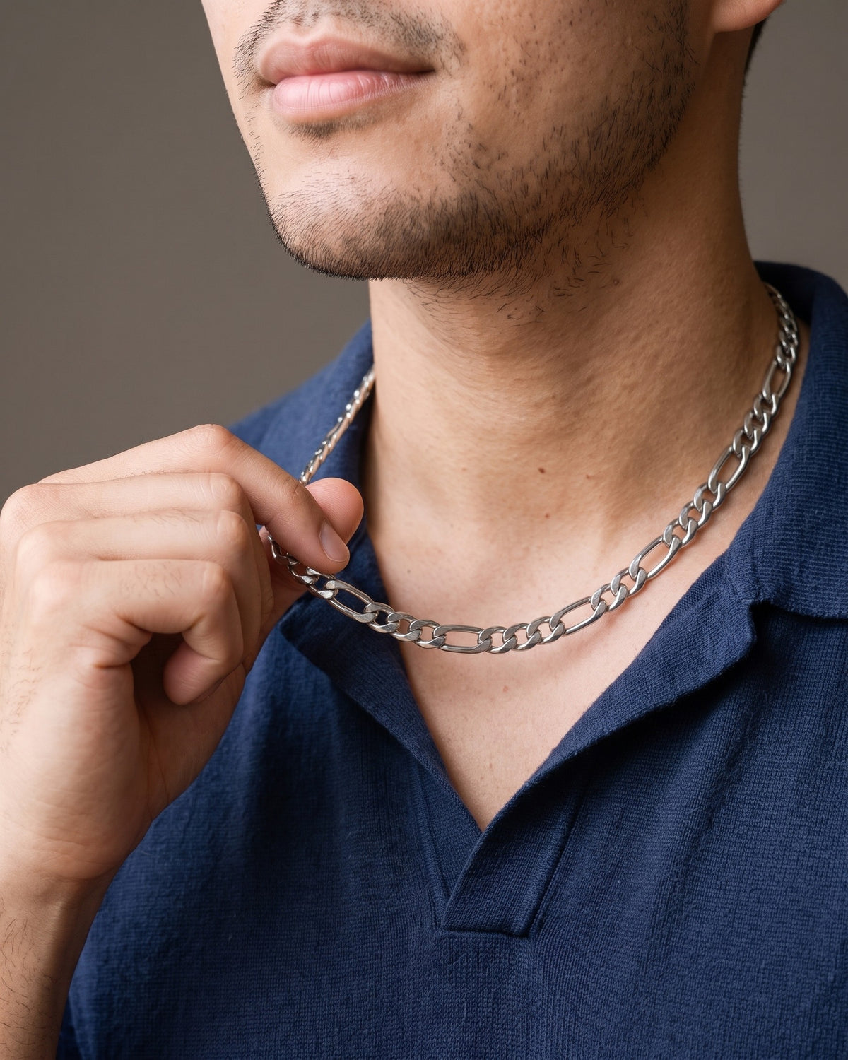 Hand lifting the Atlas Figaro Link Chain in Stainless Steel at the collarbone