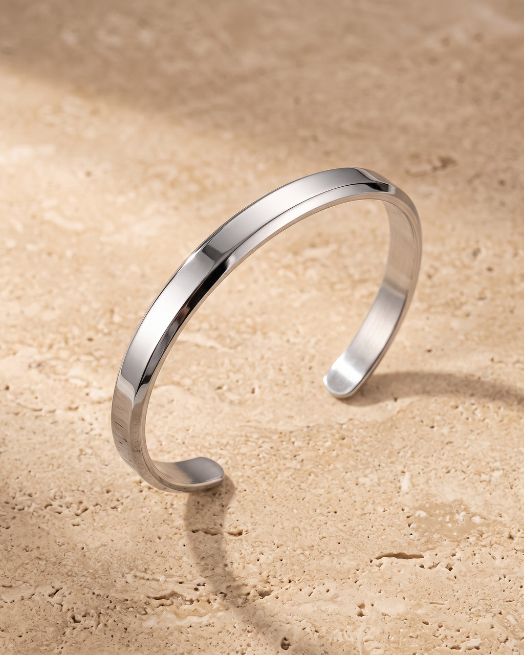 Silver Atlas flat cuff bracelet on warm stone