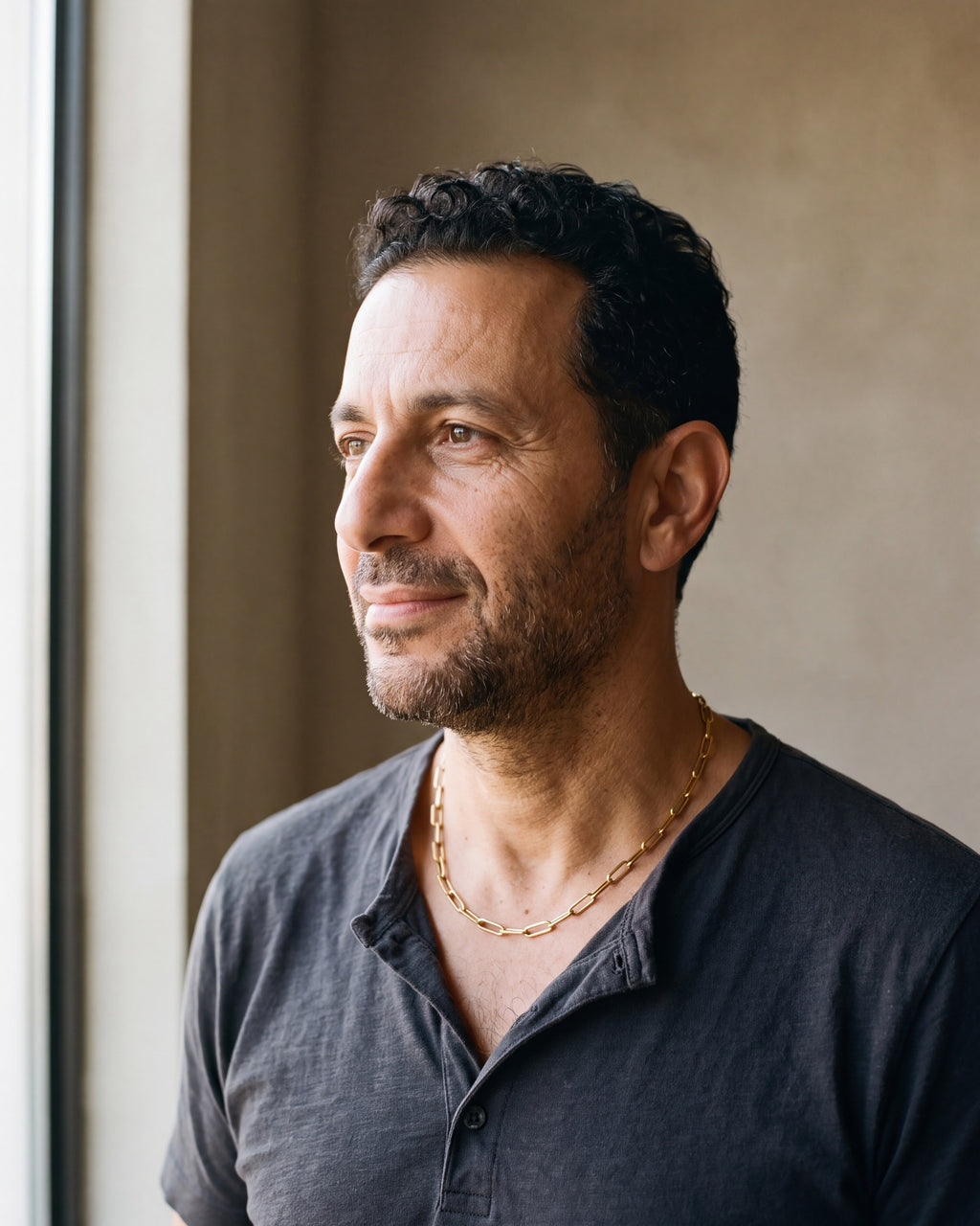 Man in a charcoal henley seen in profile wearing the gold-tone Atlas flat link chain