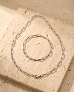 The whole silver-tone Atlas flat link chain laid on warm stone