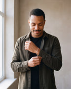 Man in an olive overshirt adjusting his sleeve wearing the silver-tone Atlas flat link chain