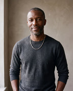 Man in a charcoal sweater with his hands in his pockets wearing the silver-tone Atlas geometric bar link chain