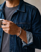 Close-up of the silver-tone Atlas geometric link cuff on a man's wrist