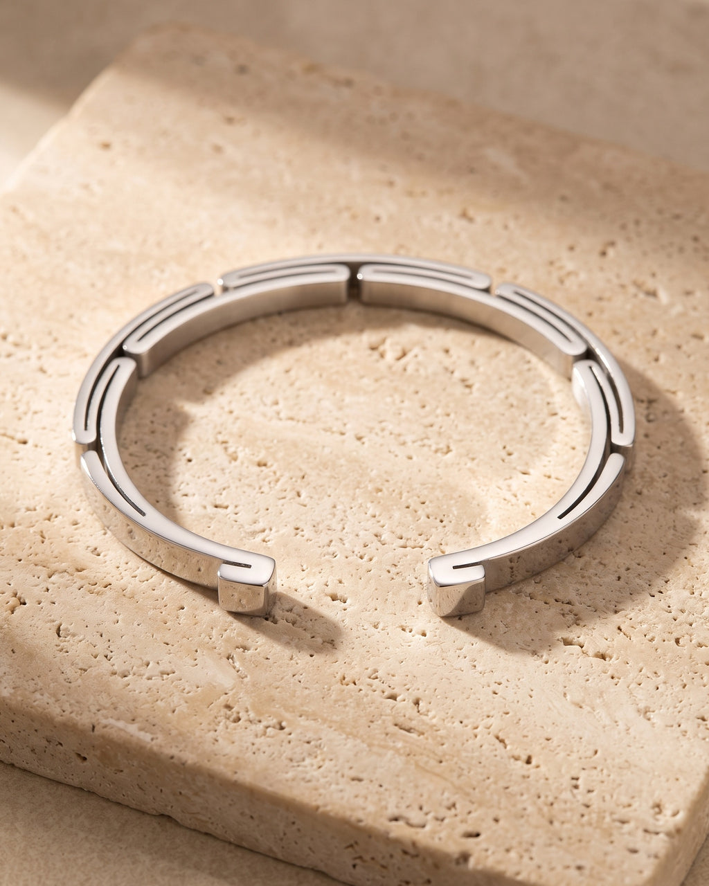 The silver-tone Atlas geometric link cuff on warm stone