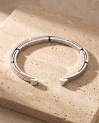 The silver-tone Atlas geometric link cuff on warm stone