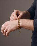 Hand adjusting the Atlas Gold-Tone Coffee Bean Link Bracelet on the wrist
