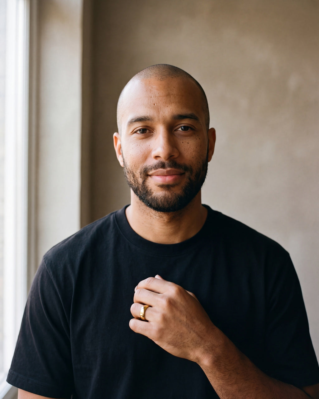 Man in a black t-shirt wearing the Atlas polished dome band in gold-tone steel