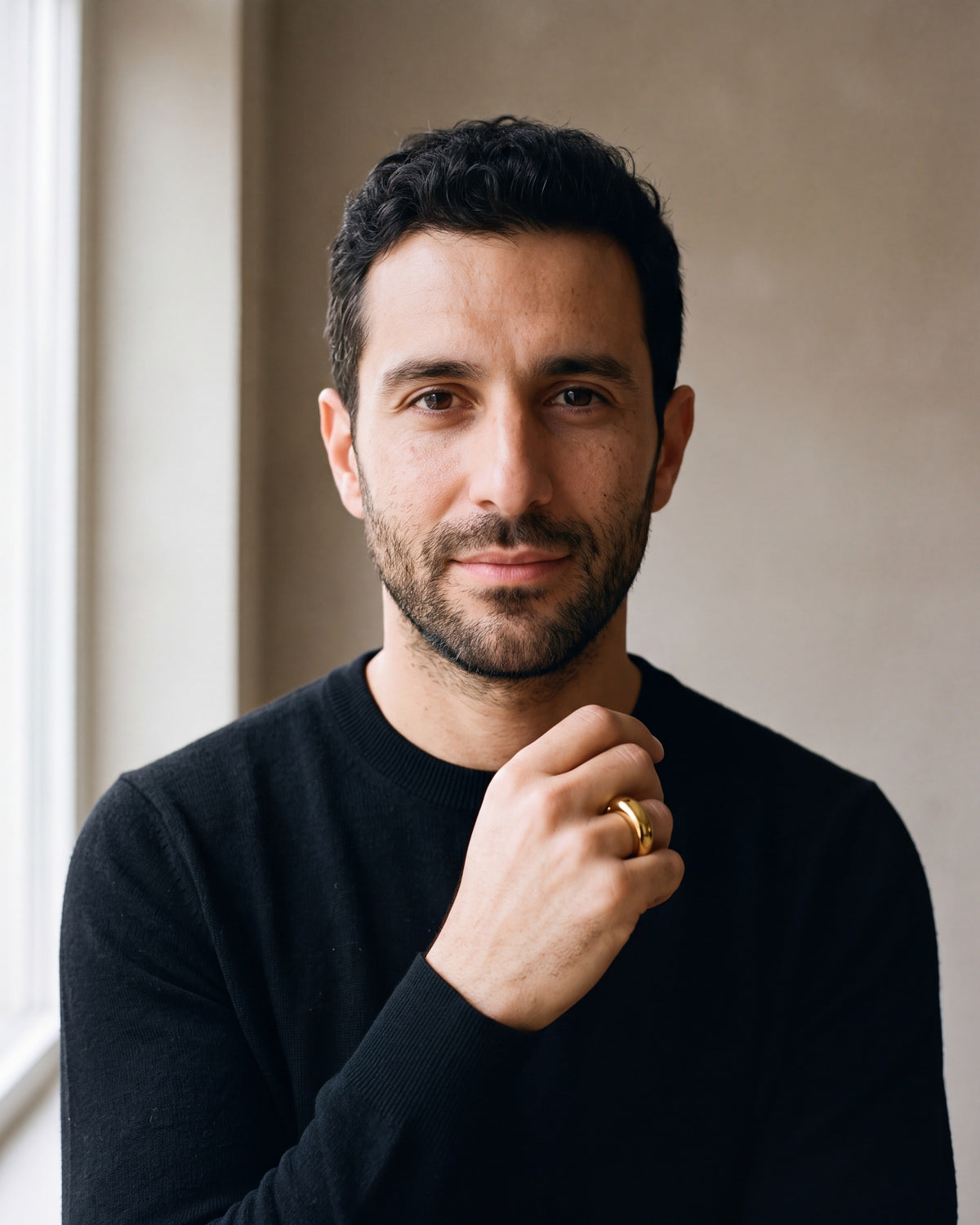 Man in a black merino crew-neck sweater wearing the gold-tone Atlas Gold-Tone Tapered Dome Ring