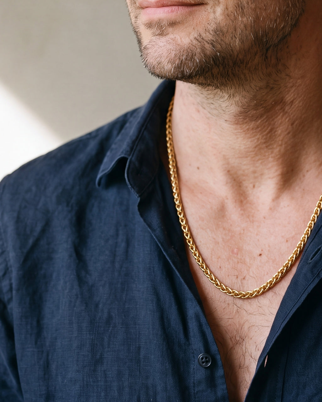 Close-up of the gold-tone Atlas gold-tone wheat chain worn by a man, shown at true size
