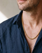 Close-up of the gold-tone Atlas gold-tone wheat chain worn by a man, shown at true size