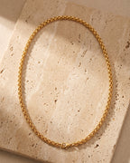 The whole gold-tone Atlas gold-tone wheat chain laid on warm stone