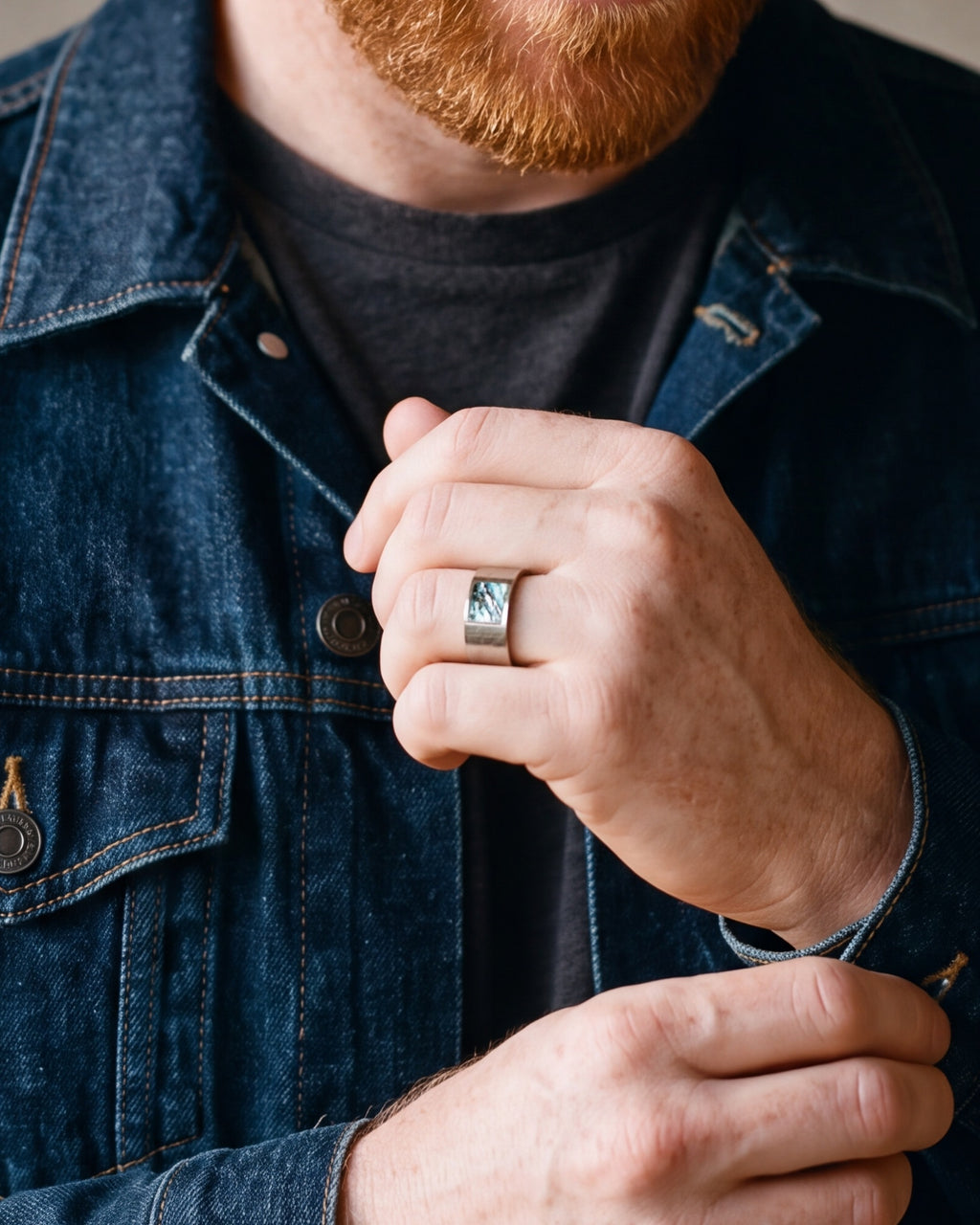 Close-up of the Atlas hammered abalone ring on a man's hand