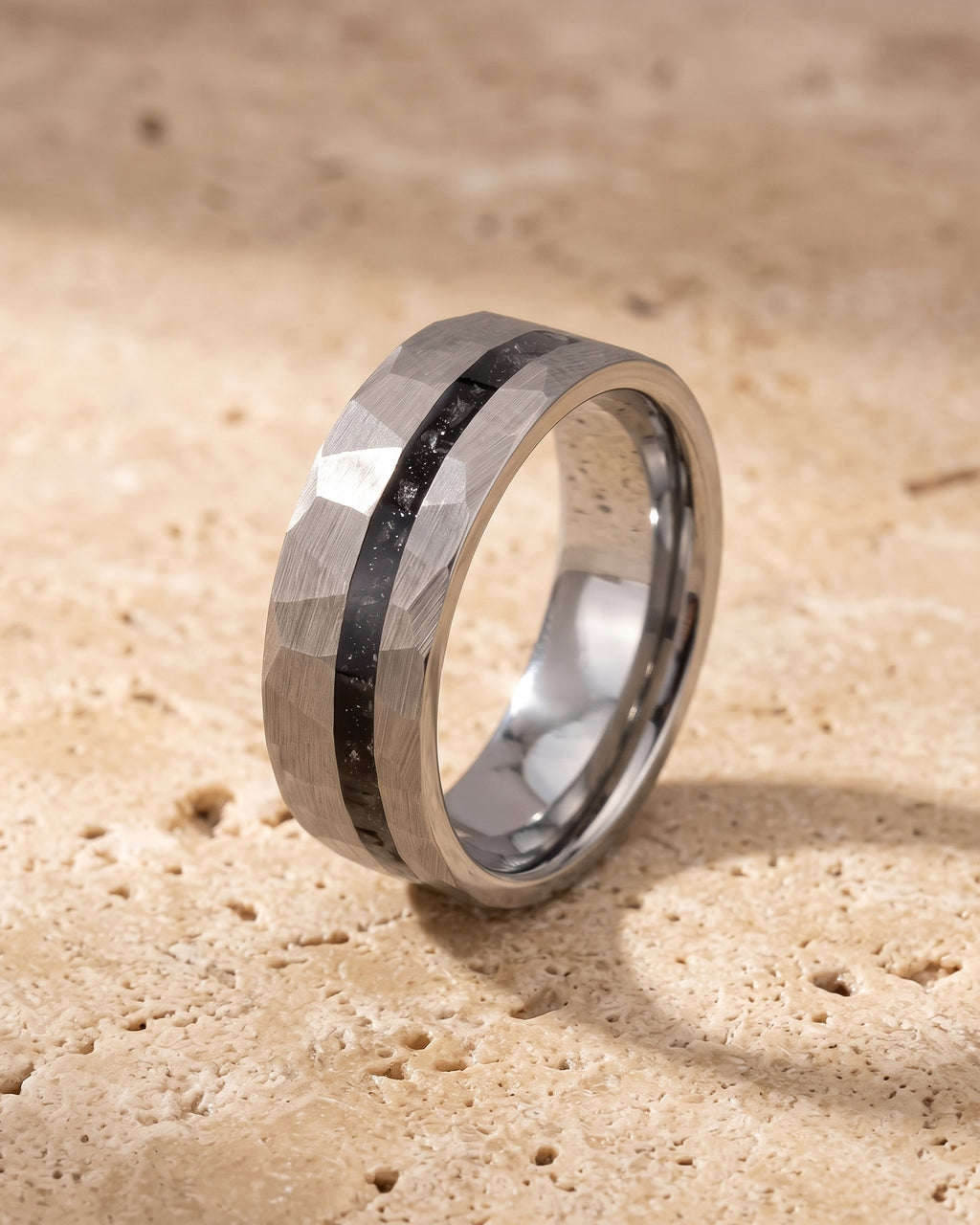 The whole silver-tone Atlas Hammered Inlay Ring lying on warm travertine stone