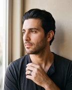 Man in a charcoal cotton henley t-shirt by a window wearing the silver-tone Atlas Hammered Inlay Ring