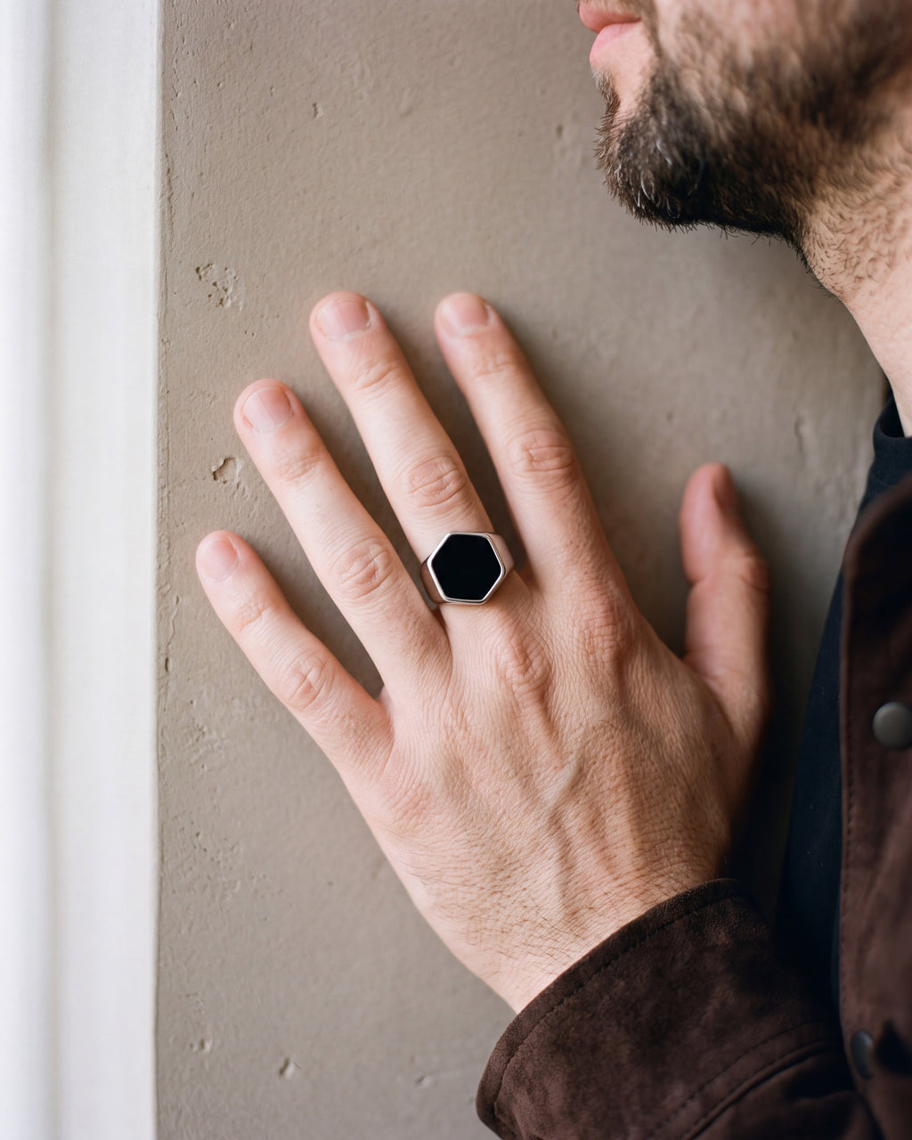 Close-up of the silver Atlas hexagon signet ring worn by a man, shown at true size