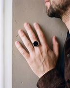 Close-up of the silver Atlas hexagon signet ring worn by a man, shown at true size