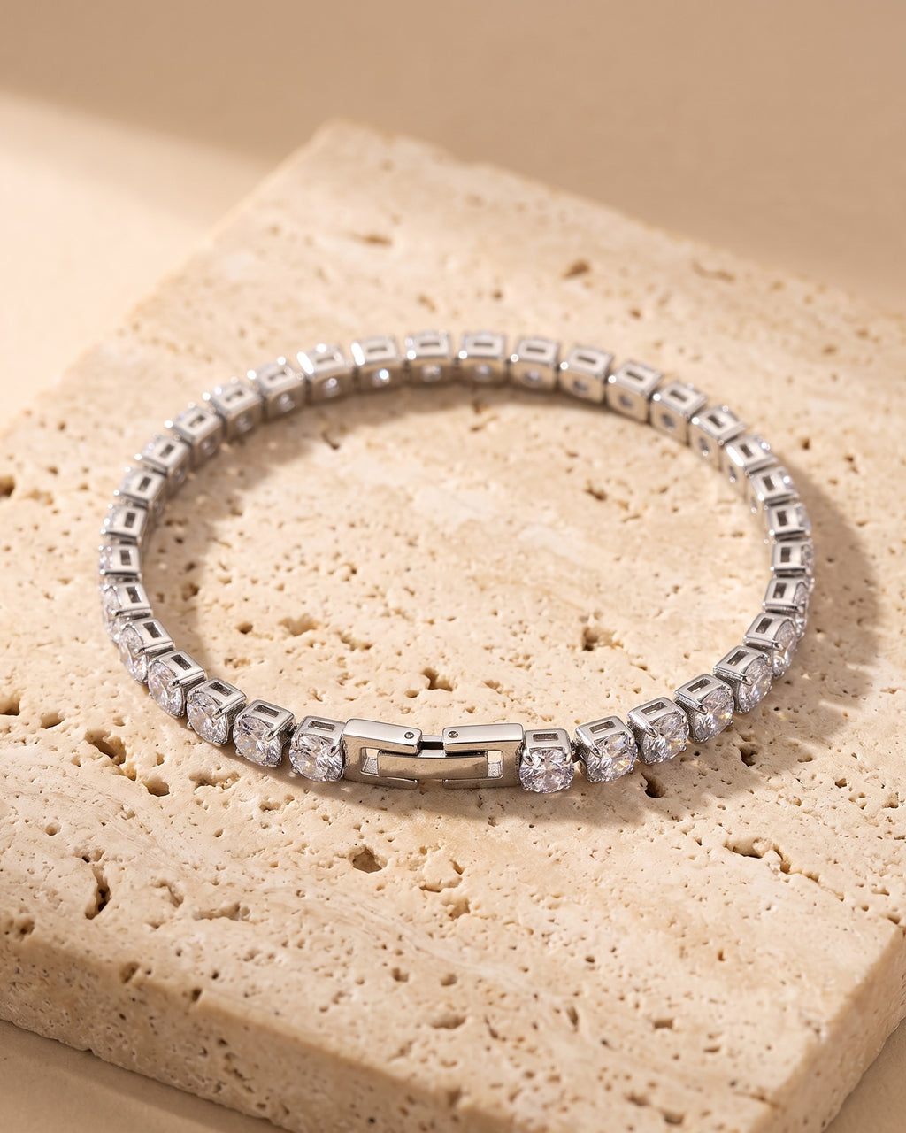 The whole silver Atlas iced tennis bracelet laid on warm stone
