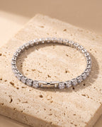 The whole silver Atlas iced tennis bracelet laid on warm stone