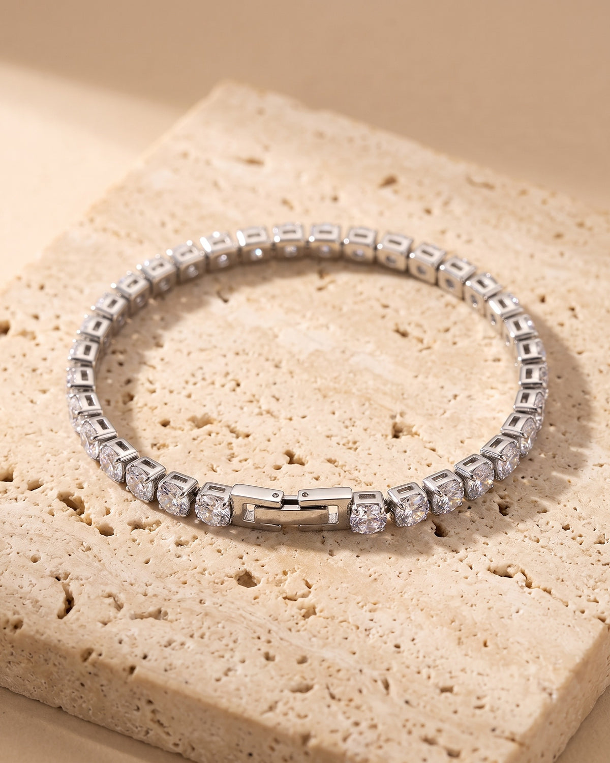 The whole silver Atlas iced tennis bracelet laid on warm stone