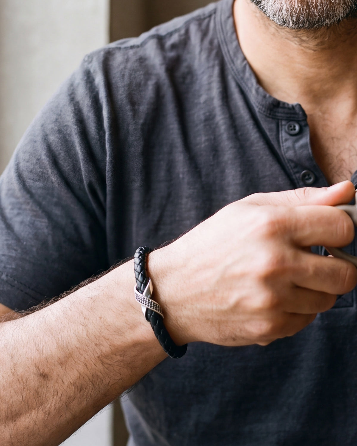 Close-up of the Atlas iced X bracelet in braided leather in silver-tone steel, worn at true size