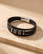 The whole silver Atlas knotwork multi-strand leather bracelet lying on warm travertine stone