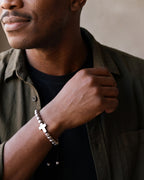 Close-up of the silver-tone Atlas cross bead bracelet on a man's wrist