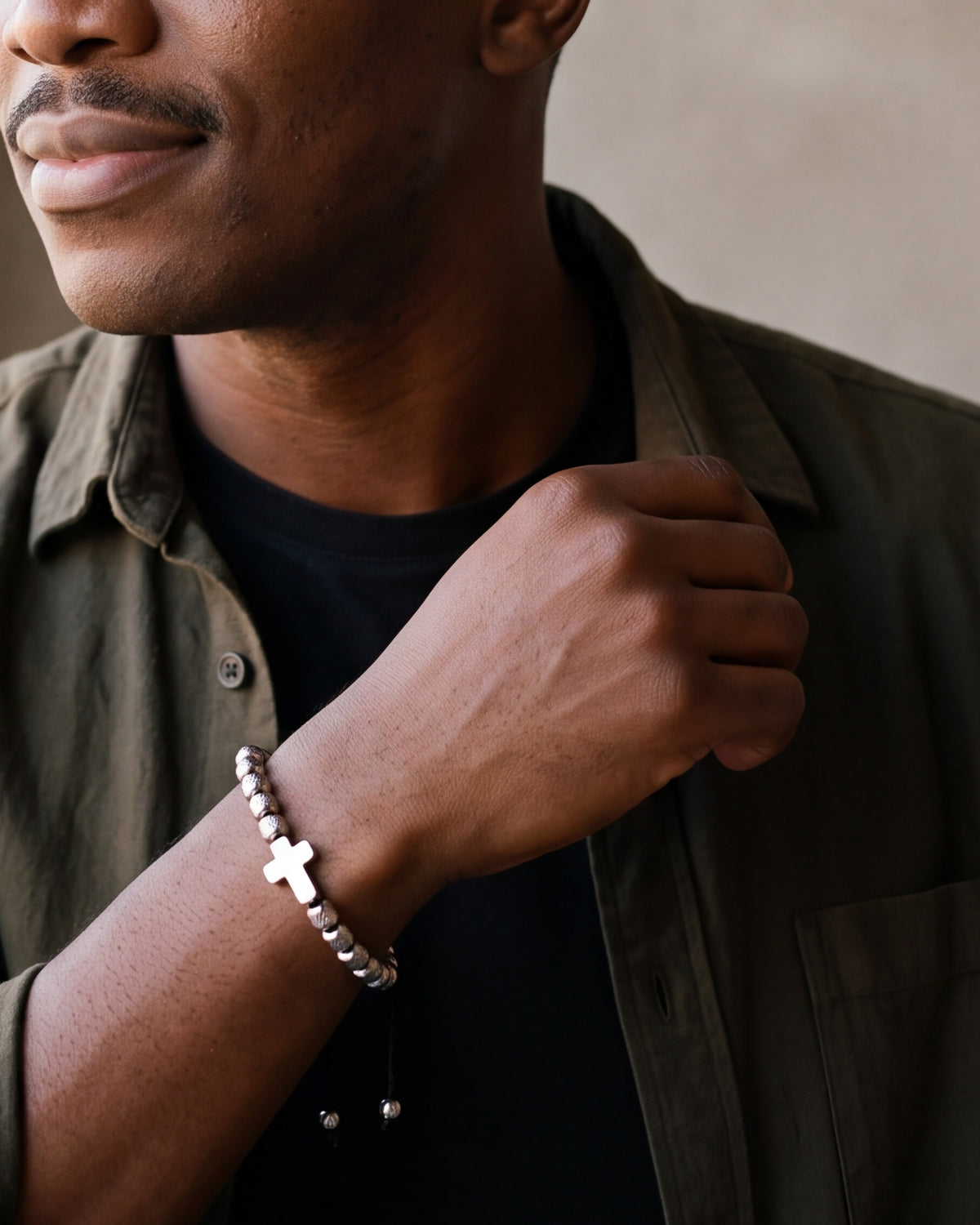 Close-up of the silver-tone Atlas cross bead bracelet on a man's wrist