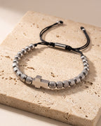 The silver-tone Atlas knurled cross bead bracelet on warm stone