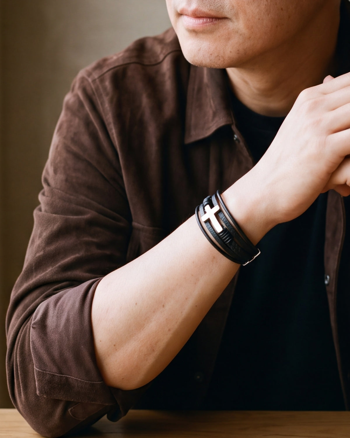 Close-up of the Atlas layered leather cross bracelet on a man's wrist