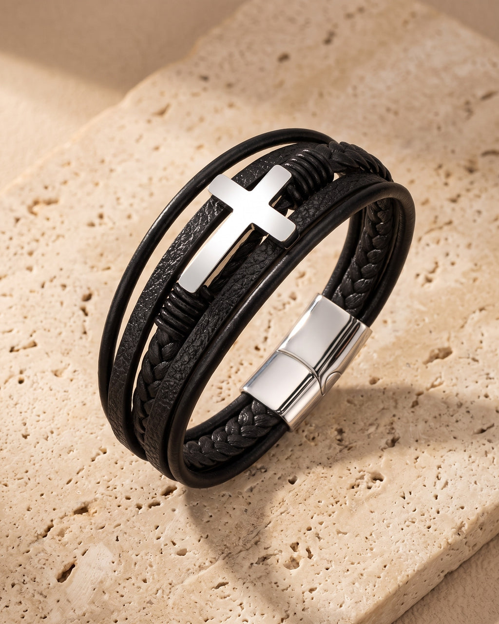 Silver Atlas layered leather cross bracelet on warm stone