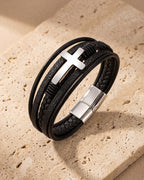 Silver Atlas layered leather cross bracelet on warm stone