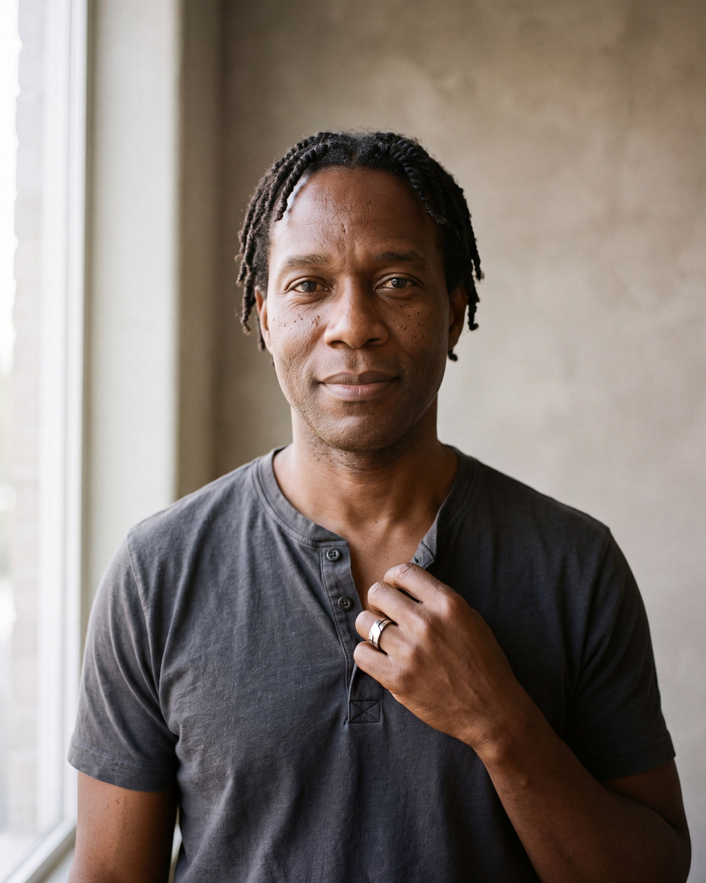 Man in a charcoal cotton henley t-shirt by a window wearing the silver Atlas layered split band ring