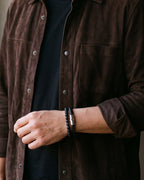 Close-up of the Atlas leather and stone bead bracelet on a man's wrist at true size