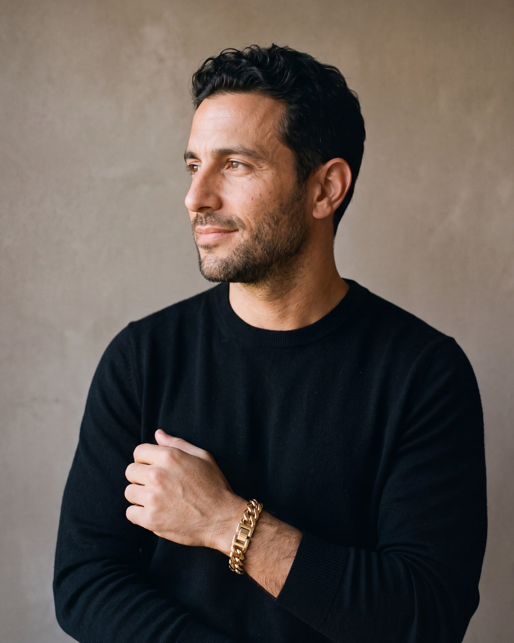 Man in a black merino crew-neck sweater wearing the gold-tone Atlas Miami Cuban Bracelet