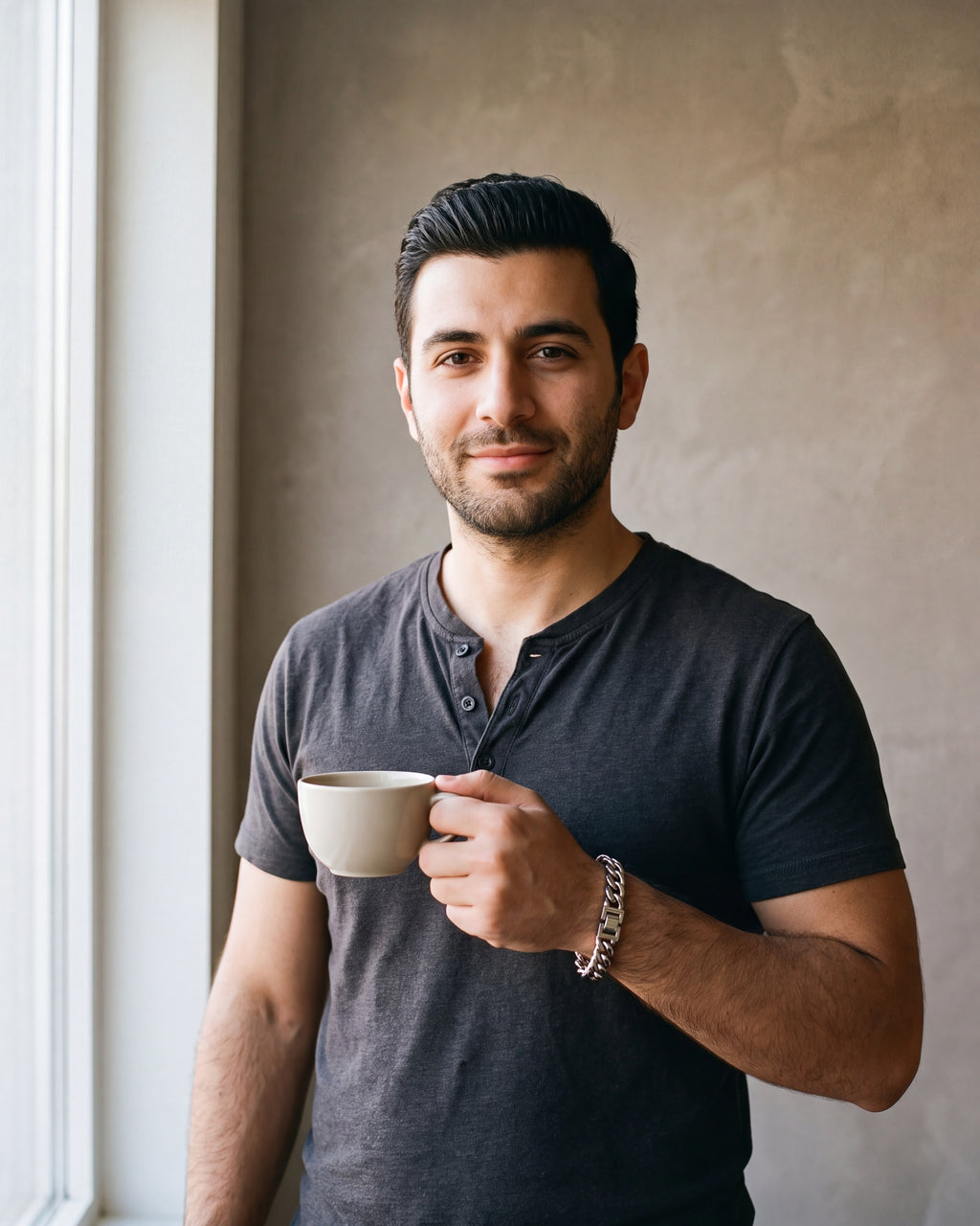 Man in a charcoal cotton henley t-shirt by a window wearing the silver-tone Atlas Miami Cuban Bracelet