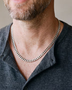 Silver Atlas Miami Cuban chain in 5 mm worn with a henley, close-up at true size