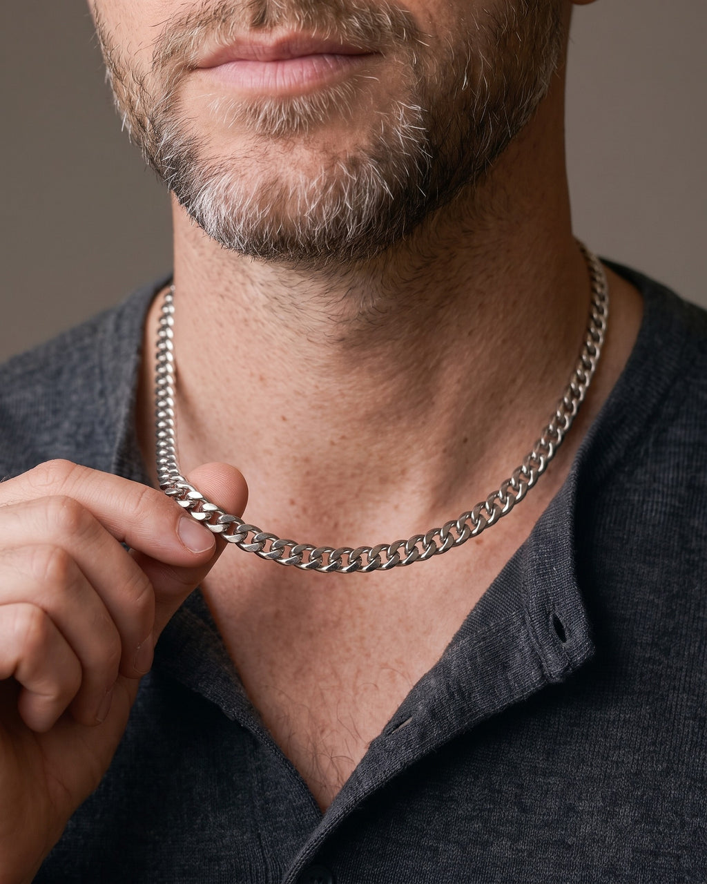 Hand lifting the Atlas Miami Cuban Link Chain at the collarbone