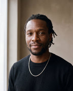 Second man in a black merino crew-neck sweater wearing the silver Atlas minimalist box chain